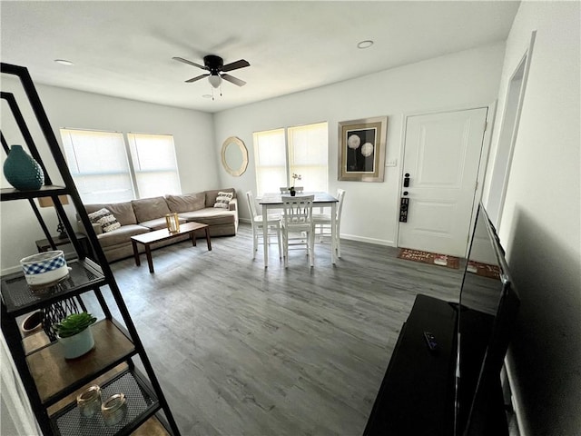 living room with ceiling fan, wood finished floors, and baseboards