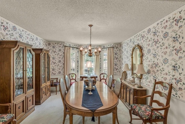 dining room featuring light carpet, a textured ceiling, and a notable chandelier