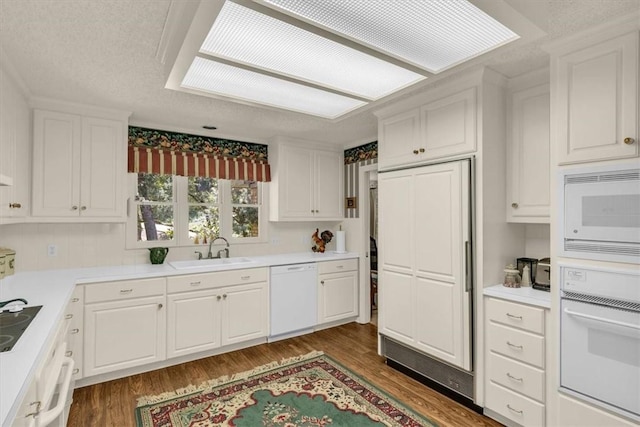 kitchen featuring white cabinets, white appliances, sink, and dark wood-type flooring