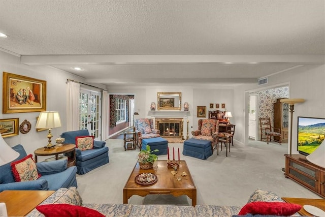 living room featuring beam ceiling, a textured ceiling, light colored carpet, and a brick fireplace