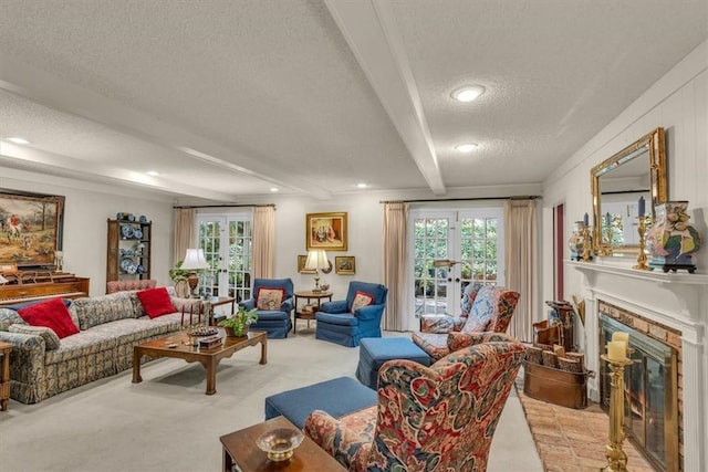 carpeted living room featuring beam ceiling, a stone fireplace, a textured ceiling, and french doors