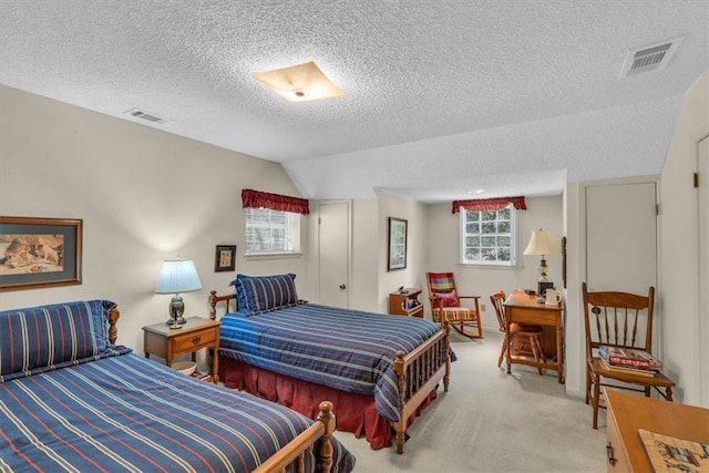 carpeted bedroom featuring a textured ceiling and lofted ceiling