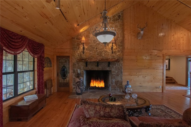 living room with wood walls, a fireplace, high vaulted ceiling, and hardwood / wood-style flooring