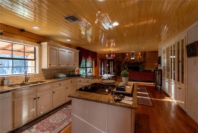 kitchen with dishwasher, sink, a center island, black electric cooktop, and hardwood / wood-style flooring