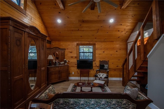 living room with wood ceiling, wooden walls, beam ceiling, light hardwood / wood-style flooring, and plenty of natural light