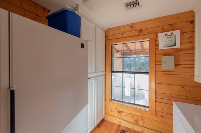 entryway featuring light hardwood / wood-style flooring and wood walls