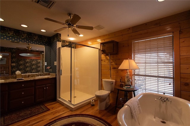 full bathroom with vanity, shower with separate bathtub, ceiling fan, hardwood / wood-style floors, and toilet