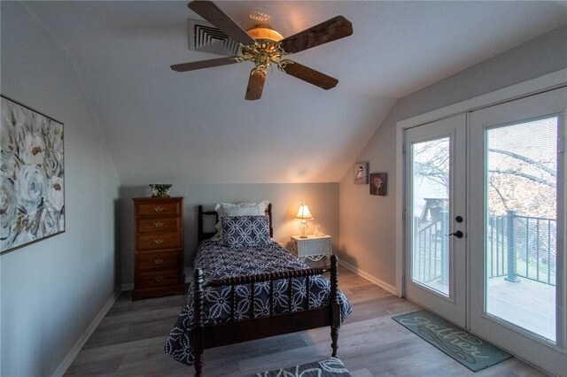 bedroom with access to exterior, ceiling fan, french doors, wood-type flooring, and vaulted ceiling