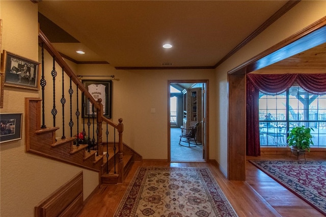 foyer with hardwood / wood-style flooring and crown molding