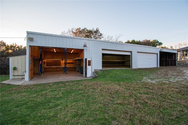 garage at dusk featuring a yard