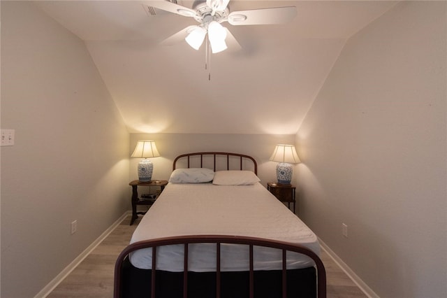 bedroom with hardwood / wood-style flooring, ceiling fan, and vaulted ceiling