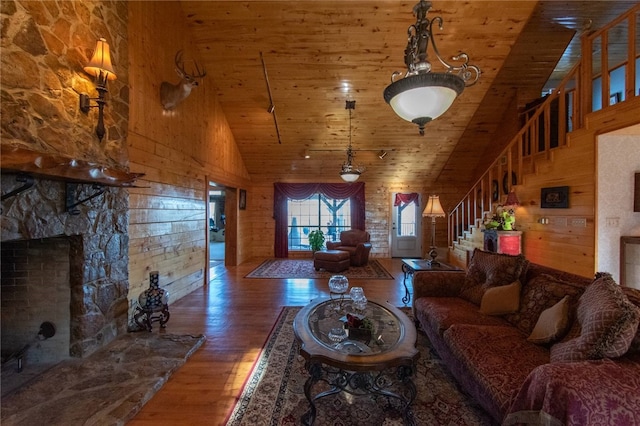 living room with dark wood-type flooring, high vaulted ceiling, track lighting, wooden walls, and wood ceiling