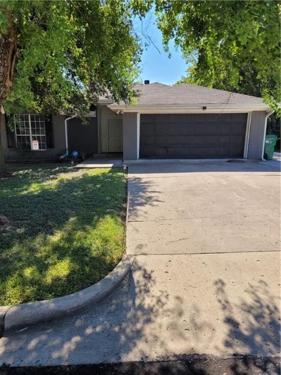 ranch-style house featuring a garage and a front yard