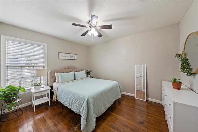 bedroom with dark hardwood / wood-style flooring and ceiling fan