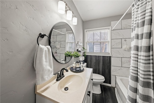 full bathroom with hardwood / wood-style flooring, vanity, shower / bath combination with curtain, and toilet