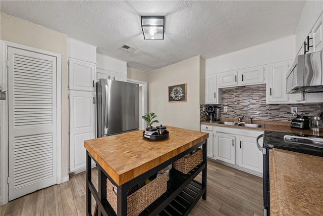 kitchen with sink, light hardwood / wood-style flooring, stainless steel appliances, and white cabinets