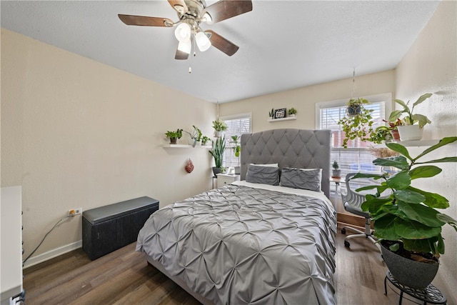 bedroom with ceiling fan and dark hardwood / wood-style floors