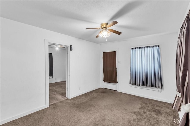 carpeted spare room featuring ceiling fan