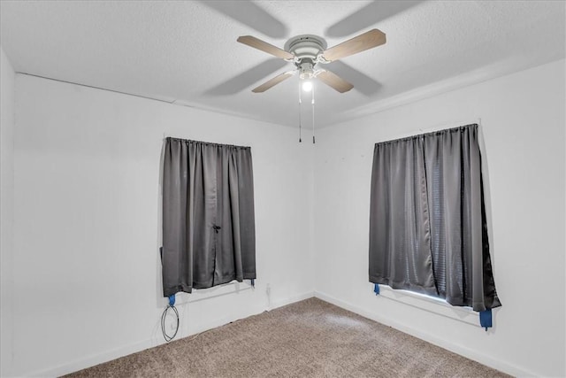 spare room featuring ceiling fan, carpet floors, and a textured ceiling