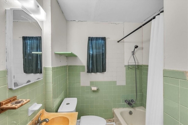 full bathroom with sink, toilet, shower / bath combo with shower curtain, and tile walls