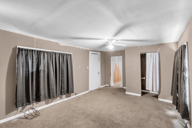 carpeted empty room featuring a textured ceiling and ceiling fan