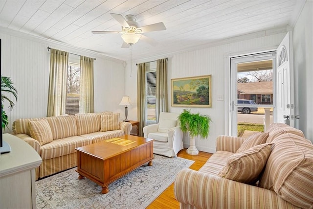 living room with light hardwood / wood-style floors, ceiling fan, ornamental molding, and wood ceiling