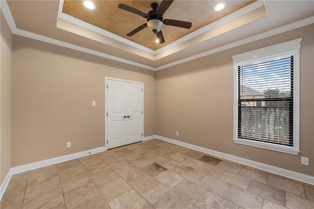 unfurnished room with a tray ceiling, crown molding, and ceiling fan