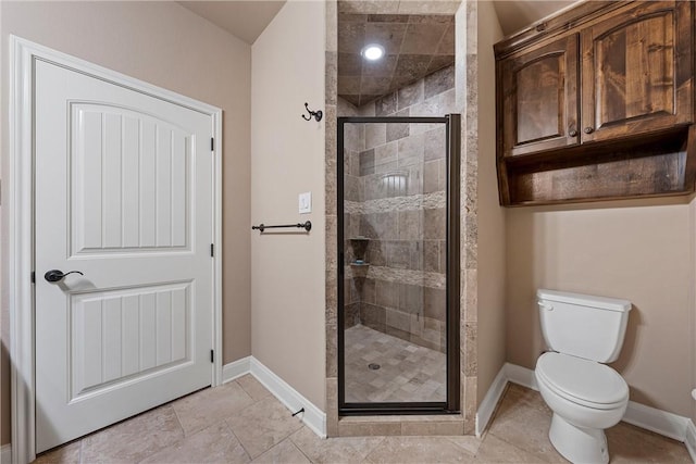 bathroom with tile patterned flooring, toilet, and a shower with shower door