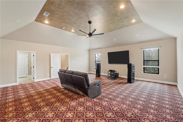 carpeted living room with ceiling fan and high vaulted ceiling