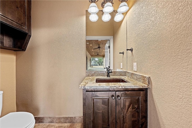 bathroom featuring tile patterned flooring, vanity, and toilet