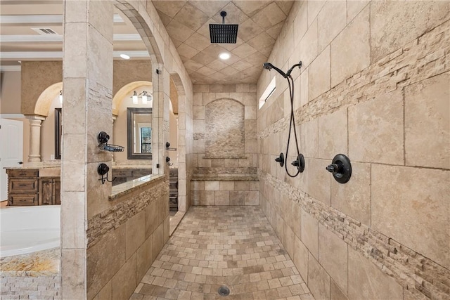 bathroom with a tile shower and decorative columns