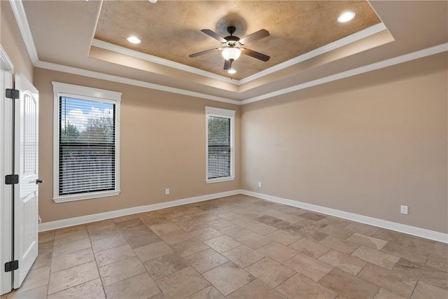 empty room featuring a tray ceiling, crown molding, and ceiling fan