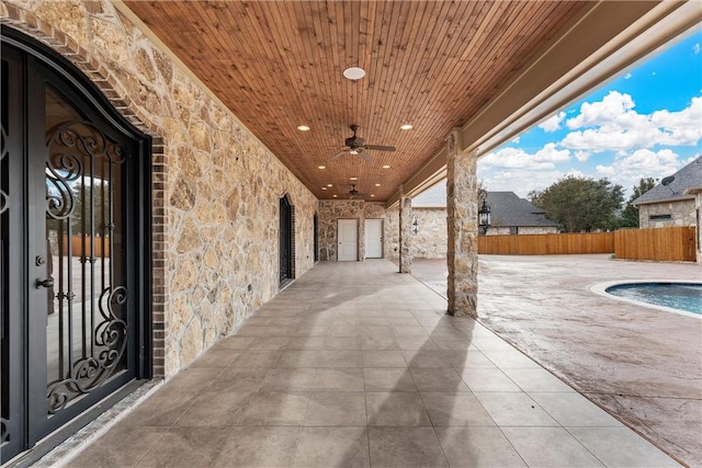 view of patio / terrace with a fenced in pool, ceiling fan, and french doors