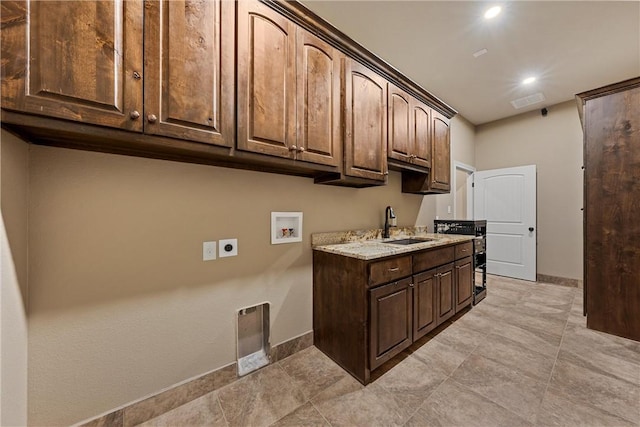 laundry room featuring electric dryer hookup, cabinets, sink, and washer hookup