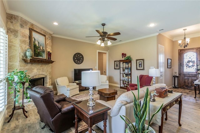 living room with a stone fireplace, a healthy amount of sunlight, crown molding, and wood-type flooring