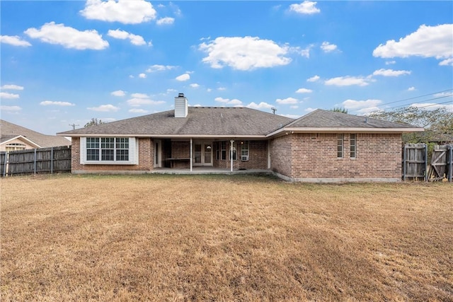 rear view of property featuring a lawn and a patio