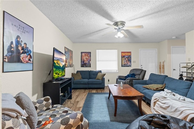 living area featuring a textured ceiling, light wood-type flooring, and ceiling fan