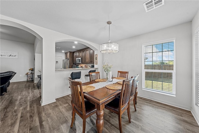 dining area featuring an inviting chandelier and dark wood-type flooring