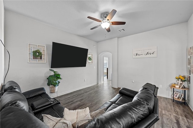 living room featuring ceiling fan and dark wood-type flooring