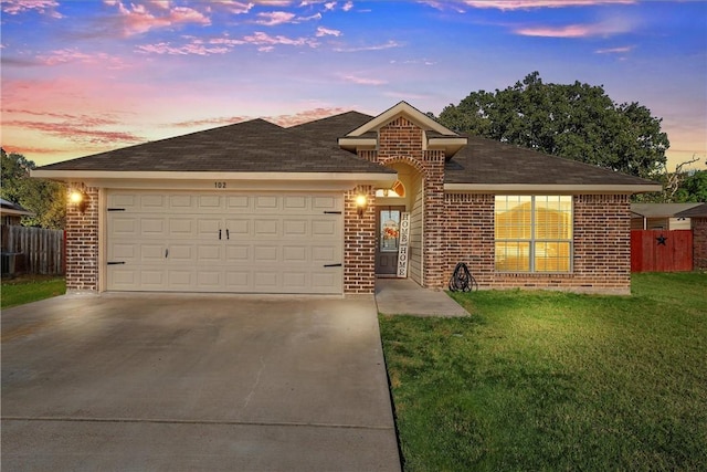 ranch-style house featuring a yard and a garage