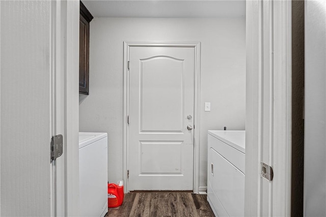 washroom featuring washing machine and clothes dryer, dark hardwood / wood-style flooring, and cabinets