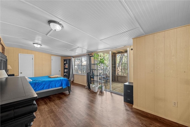 bedroom featuring dark hardwood / wood-style floors, vaulted ceiling, and wooden walls