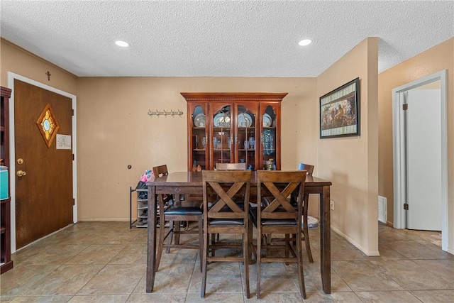 tiled dining room with a textured ceiling