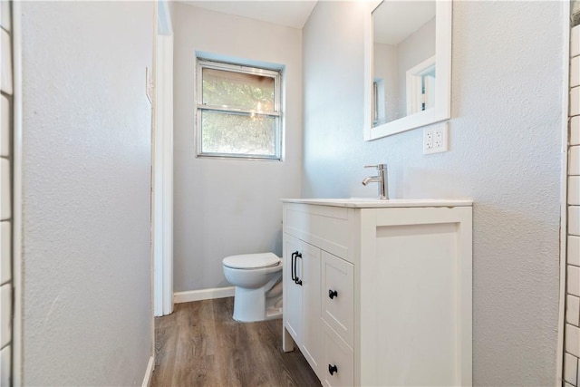 bathroom featuring hardwood / wood-style flooring, vanity, and toilet