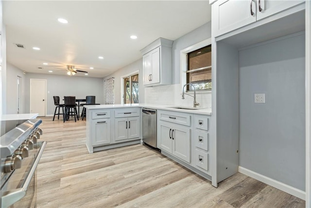 kitchen with ceiling fan, sink, appliances with stainless steel finishes, and light hardwood / wood-style flooring