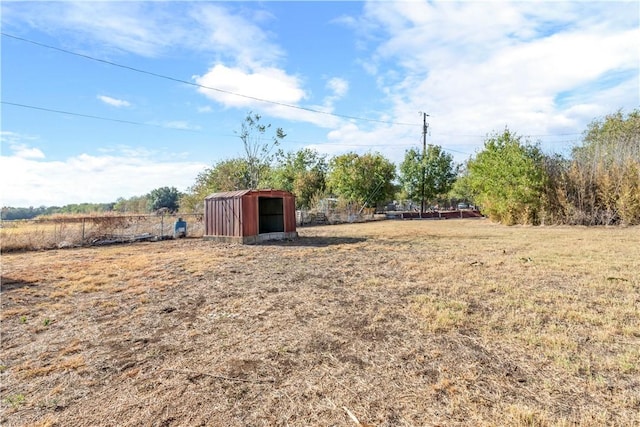 view of yard featuring a rural view and a shed