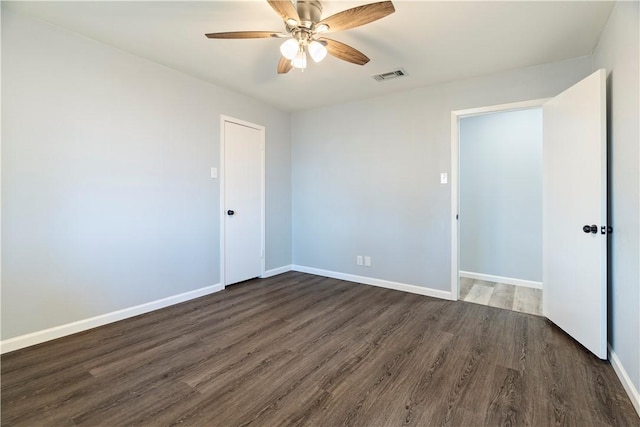 spare room with ceiling fan and dark hardwood / wood-style flooring