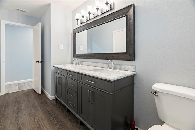 bathroom featuring vanity, hardwood / wood-style flooring, and toilet