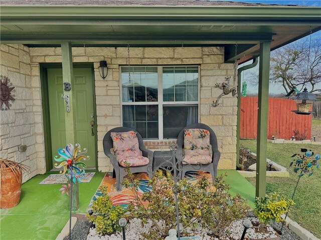 view of patio featuring a porch and fence