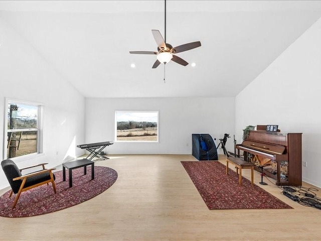 living area with high vaulted ceiling, a wealth of natural light, light hardwood / wood-style floors, and ceiling fan